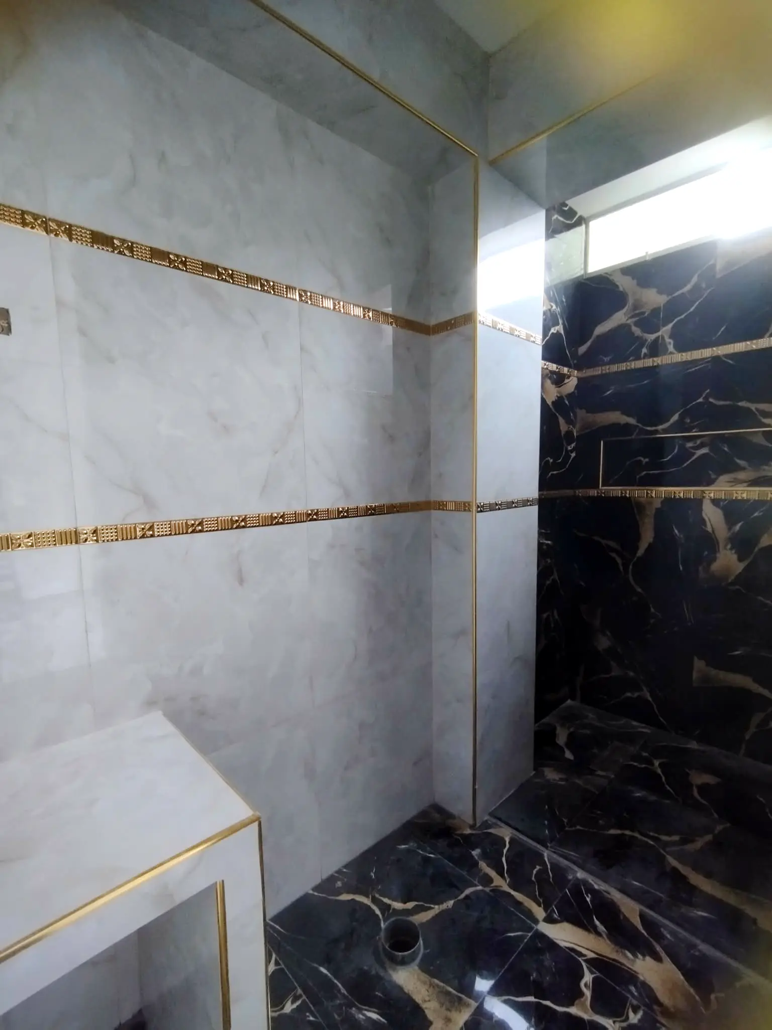 Enchape de bano con mayolica y perfil dorado