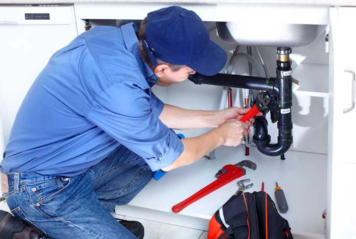 Gasfitero profesional reparando tuberías en cocina Lima